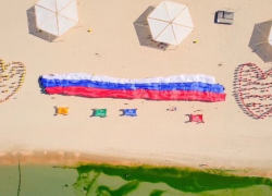 На пляже Анапы развернули 100-метровый российский триколор: в городе отмечают день флага России